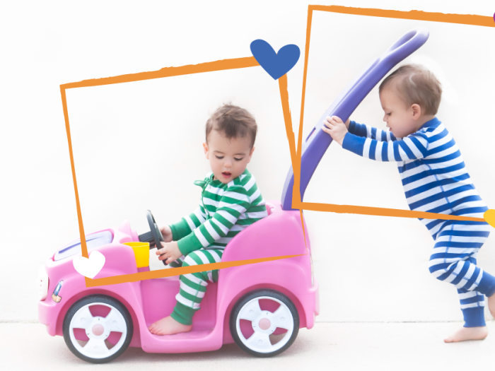 two toddlers with striped jammies on playing with a tow car